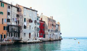 Charming vintage buildings beside a clear sea with rustic facades and scenic views.